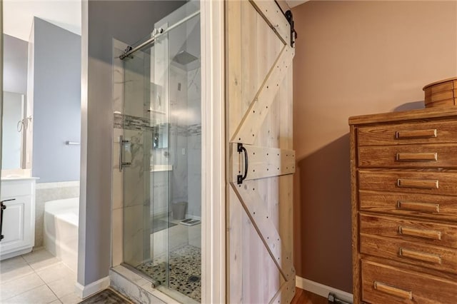full bath with tile patterned floors, a bath, vanity, and a stall shower