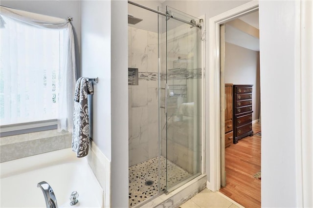 full bathroom with a garden tub, tile patterned flooring, and a shower stall