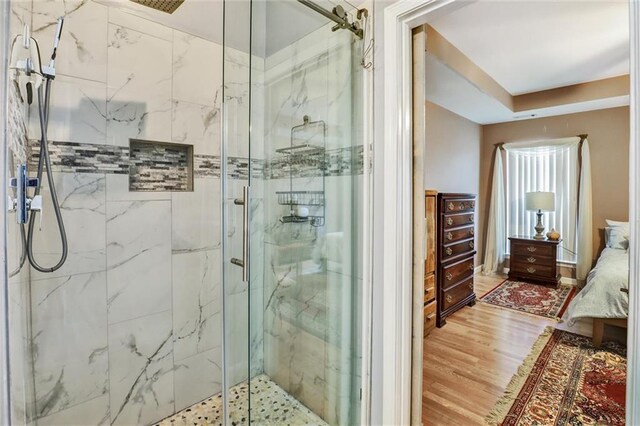 ensuite bathroom featuring ensuite bath, a marble finish shower, and wood finished floors