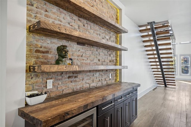 bar with wood-type flooring, beverage cooler, and butcher block countertops