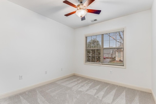 carpeted spare room with ceiling fan