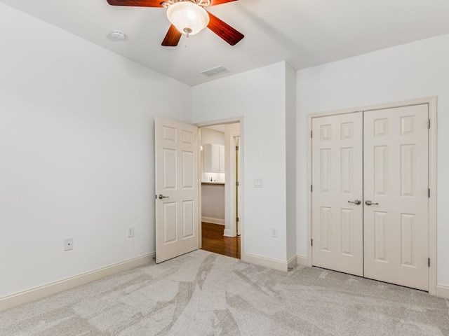 unfurnished bedroom with light carpet, a closet, and ceiling fan