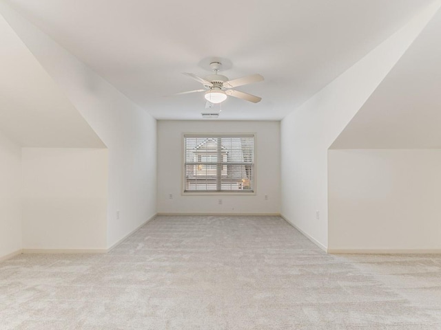 additional living space with ceiling fan and light colored carpet