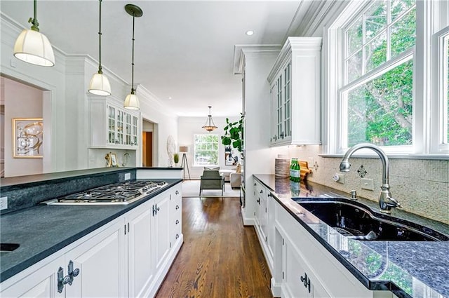 kitchen with decorative light fixtures, dark wood-type flooring, sink, crown molding, and stainless steel gas cooktop