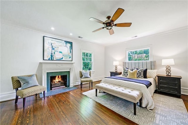 bedroom featuring dark hardwood / wood-style flooring, ceiling fan, ornamental molding, and multiple windows