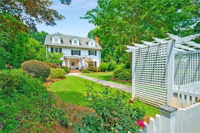 view of front of property with a pergola and a front lawn