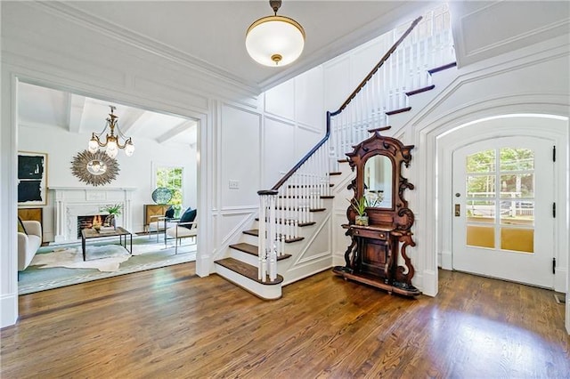 foyer entrance with a chandelier, dark hardwood / wood-style floors, and beamed ceiling