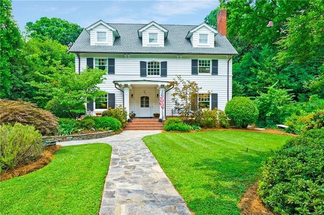 colonial inspired home featuring a front lawn