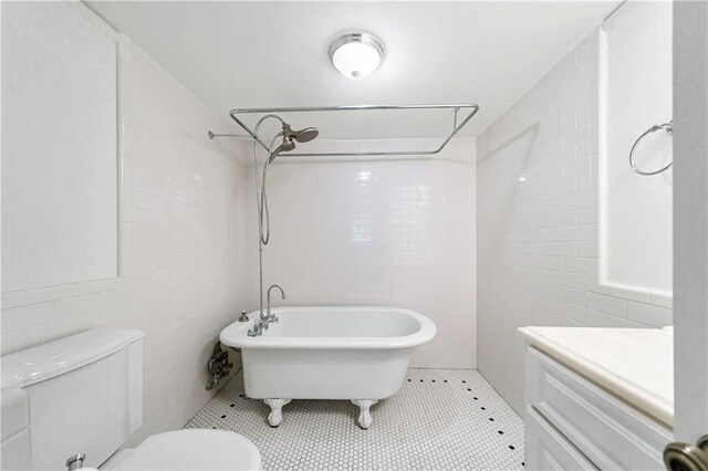 bathroom featuring tile walls, toilet, and tile floors