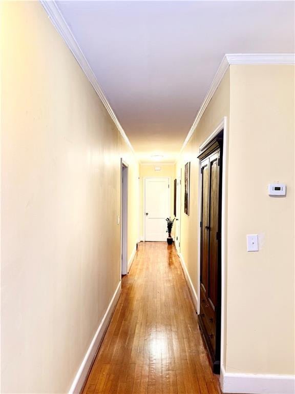 hall with ornamental molding and hardwood / wood-style floors