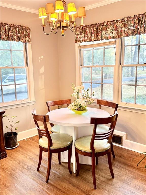 dining space featuring crown molding, a chandelier, and hardwood / wood-style floors