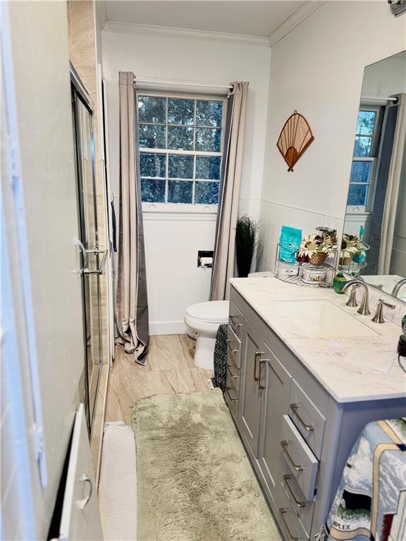 bathroom featuring crown molding, vanity, and toilet