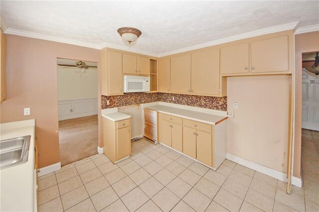 4161 Windermere Dr, Lithonia, GA 30038 - kitchen with ornamental molding, a ceiling fan, a sink, cream cabinets, and white microwave