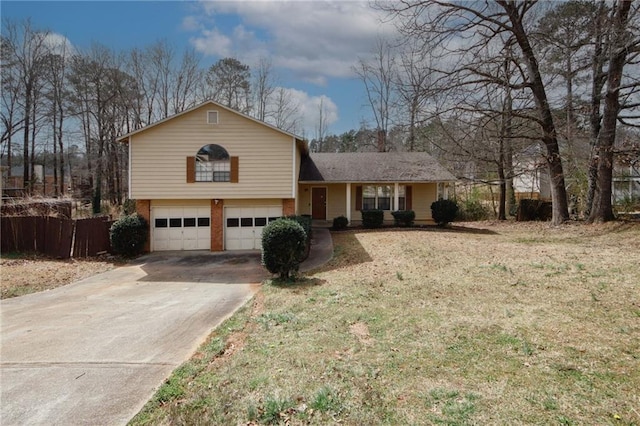 split level home with driveway, brick siding, an attached garage, and fence