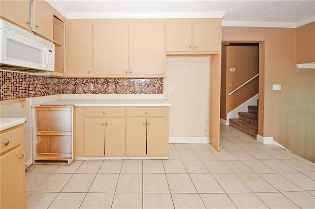 4161 Windermere Dr, Lithonia, GA 30038 - kitchen featuring white microwave, tasteful backsplash, crown molding, light countertops, and light tile patterned floors