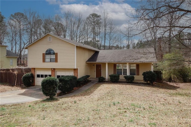 split level home featuring brick siding, concrete driveway, a garage, and a front yard