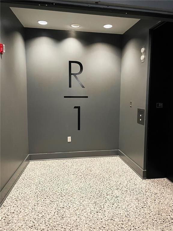 845 Spring St NW Unit 129, Atlanta, GA 30308 - detailed view of baseboards, elevator, and speckle patterned floor