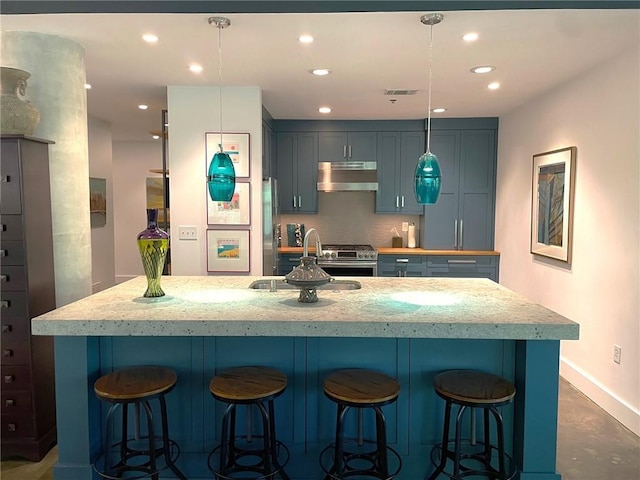 845 Spring St NW Unit 129, Atlanta, GA 30308 - kitchen featuring under cabinet range hood, a sink, gas range, baseboards, and a center island with sink