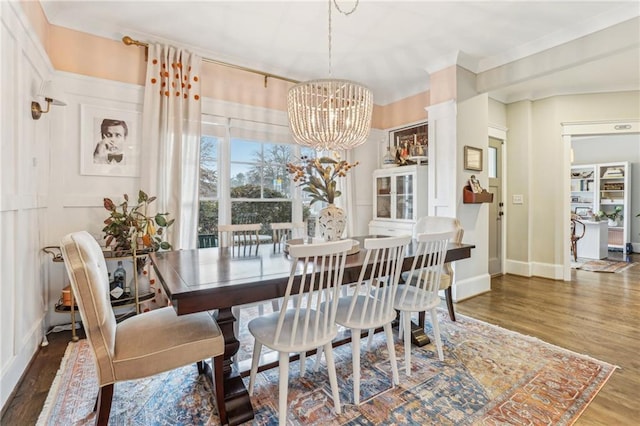 dining area featuring ornamental molding, a chandelier, and dark hardwood / wood-style flooring