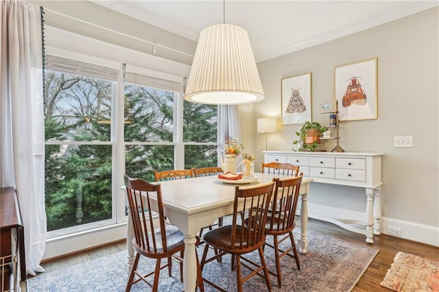 dining area with ornamental molding and dark hardwood / wood-style floors