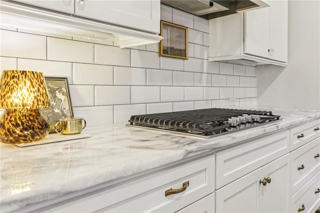 kitchen featuring white cabinetry, wall chimney exhaust hood, and stainless steel gas cooktop