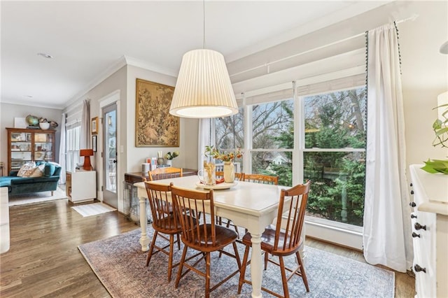 dining space featuring dark hardwood / wood-style flooring, plenty of natural light, and ornamental molding