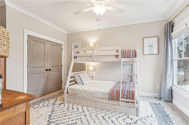 bedroom featuring ornamental molding, carpet floors, ceiling fan, and a closet