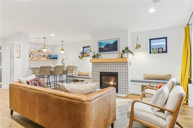 living room with light hardwood / wood-style floors and a tile fireplace