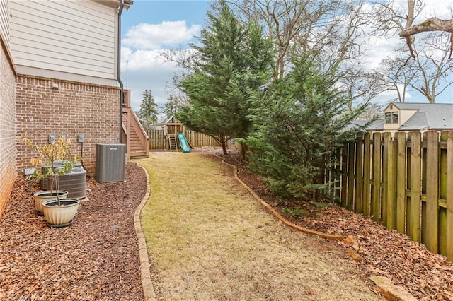 view of yard featuring central AC unit and a playground