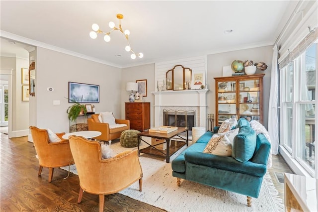 living room featuring hardwood / wood-style flooring, ornamental molding, and an inviting chandelier