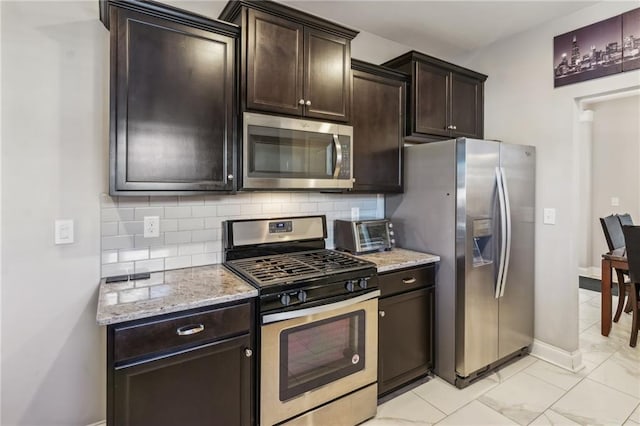 kitchen featuring tasteful backsplash, dark brown cabinetry, and appliances with stainless steel finishes