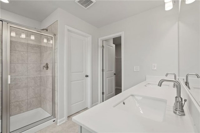 bathroom featuring a shower with door, tile patterned floors, and vanity