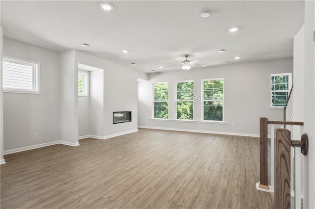 unfurnished living room with light wood-type flooring and ceiling fan