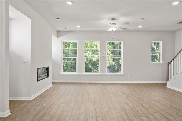 unfurnished living room with ceiling fan and light hardwood / wood-style floors