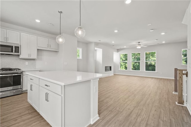 kitchen featuring appliances with stainless steel finishes, white cabinetry, and a healthy amount of sunlight