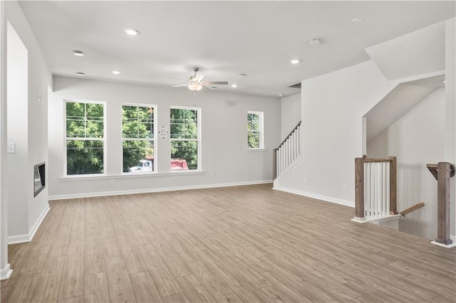 unfurnished living room featuring ceiling fan and light hardwood / wood-style floors