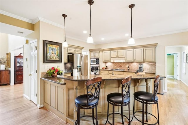 kitchen with light wood-type flooring, stainless steel appliances, tasteful backsplash, and cream cabinets