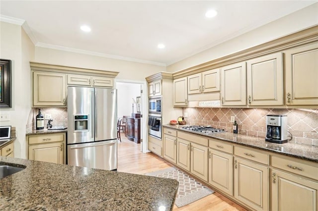 kitchen featuring cream cabinetry, appliances with stainless steel finishes, and light wood-style flooring
