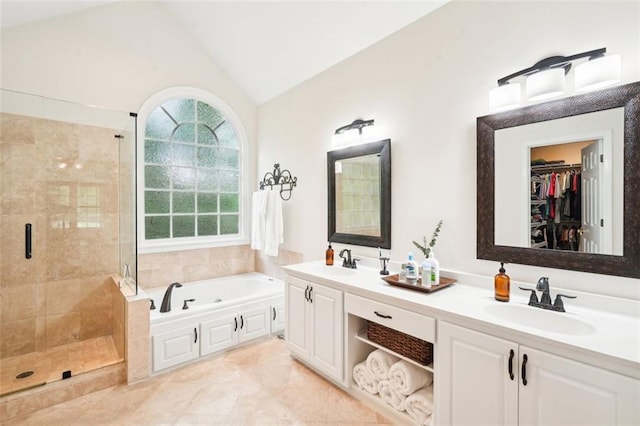 bathroom with a sink, double vanity, lofted ceiling, a shower stall, and a garden tub