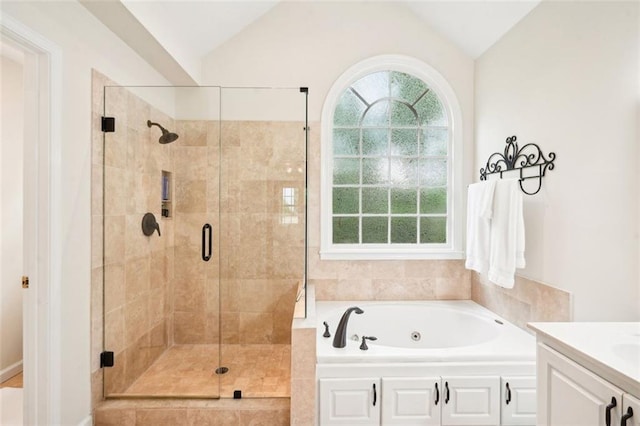 bathroom featuring lofted ceiling, a whirlpool tub, vanity, and a stall shower