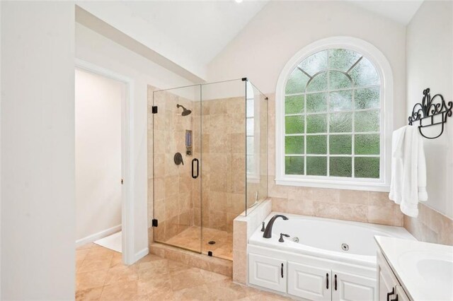 full bathroom featuring lofted ceiling, a healthy amount of sunlight, a jetted tub, and a stall shower