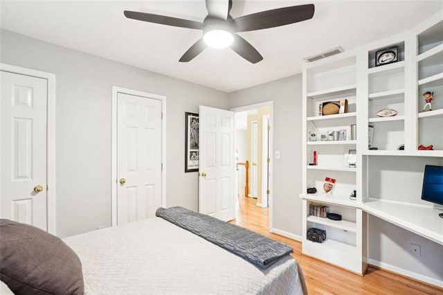 bedroom featuring light wood-type flooring, visible vents, baseboards, and ceiling fan