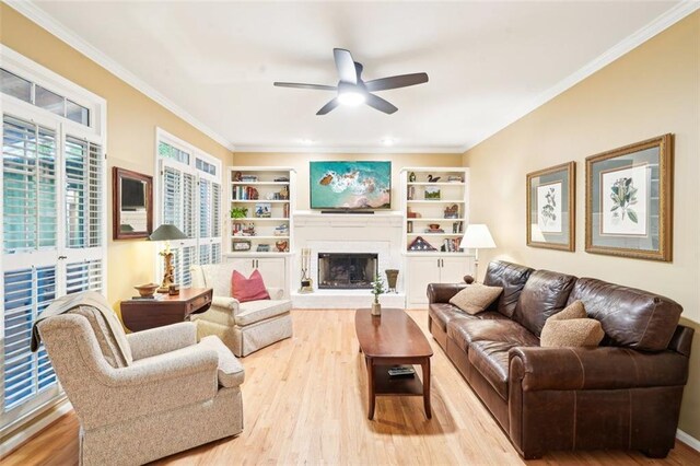 living area with ornamental molding, wood finished floors, and ceiling fan