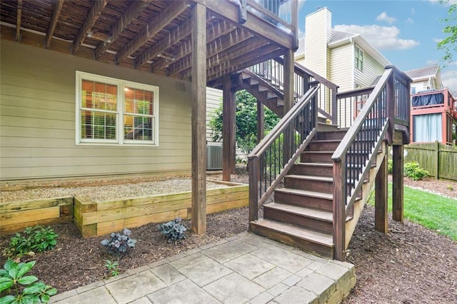 exterior space with central AC unit, stairway, fence, and a wooden deck