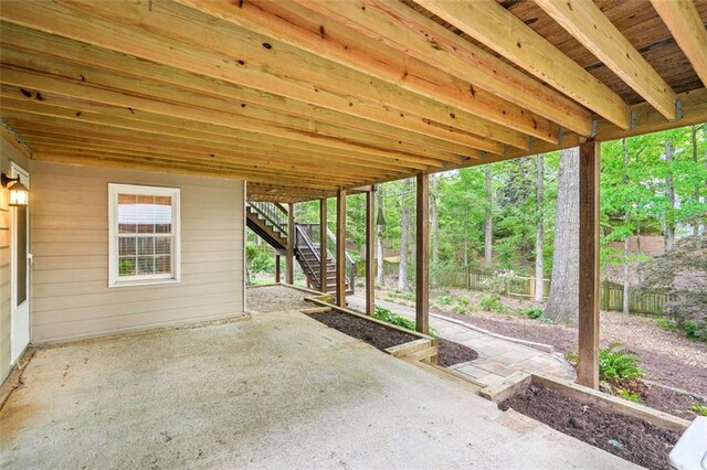 view of patio featuring fence and stairs