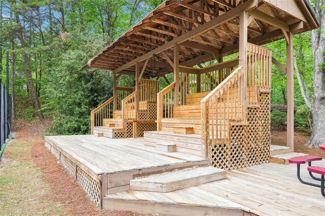 wooden terrace with a ceiling fan and stairs