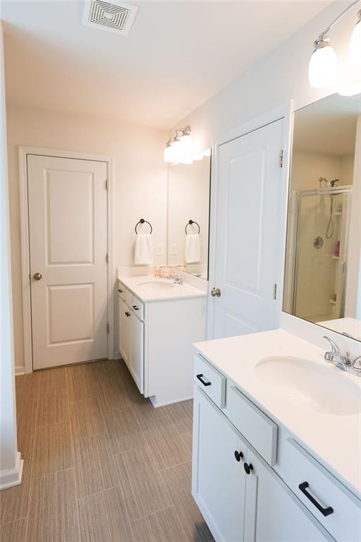 382 Winston Cir, Canton, GA 30114 - bathroom featuring a stall shower and two vanities