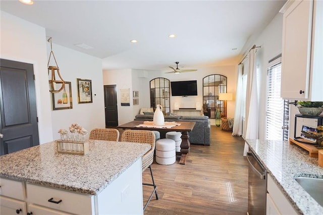 382 Winston Cir, Canton, GA 30114 - kitchen featuring stainless steel dishwasher, wood finished floors, a breakfast bar area, a ceiling fan, and white cabinets