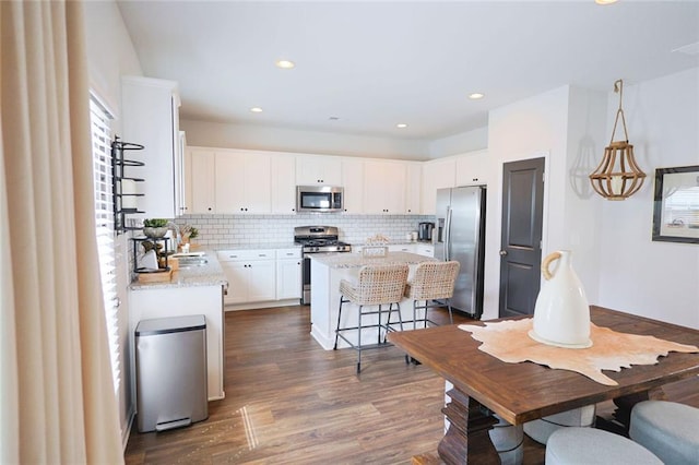 382 Winston Cir, Canton, GA 30114 - kitchen featuring stainless steel appliances, a kitchen island, tasteful backsplash, dark wood finished floors, and white cabinets