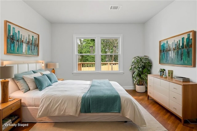 bedroom featuring wood finished floors and visible vents